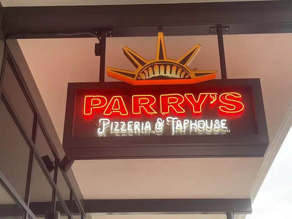 Neon sign for Parry's Pizzeria & Taphouse with a stylized sunburst design above the text.
