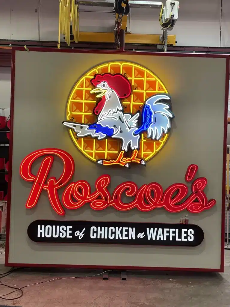 Neon sign displaying "Roscoe's House of Chicken 'n Waffles" with a rooster and waffle design.