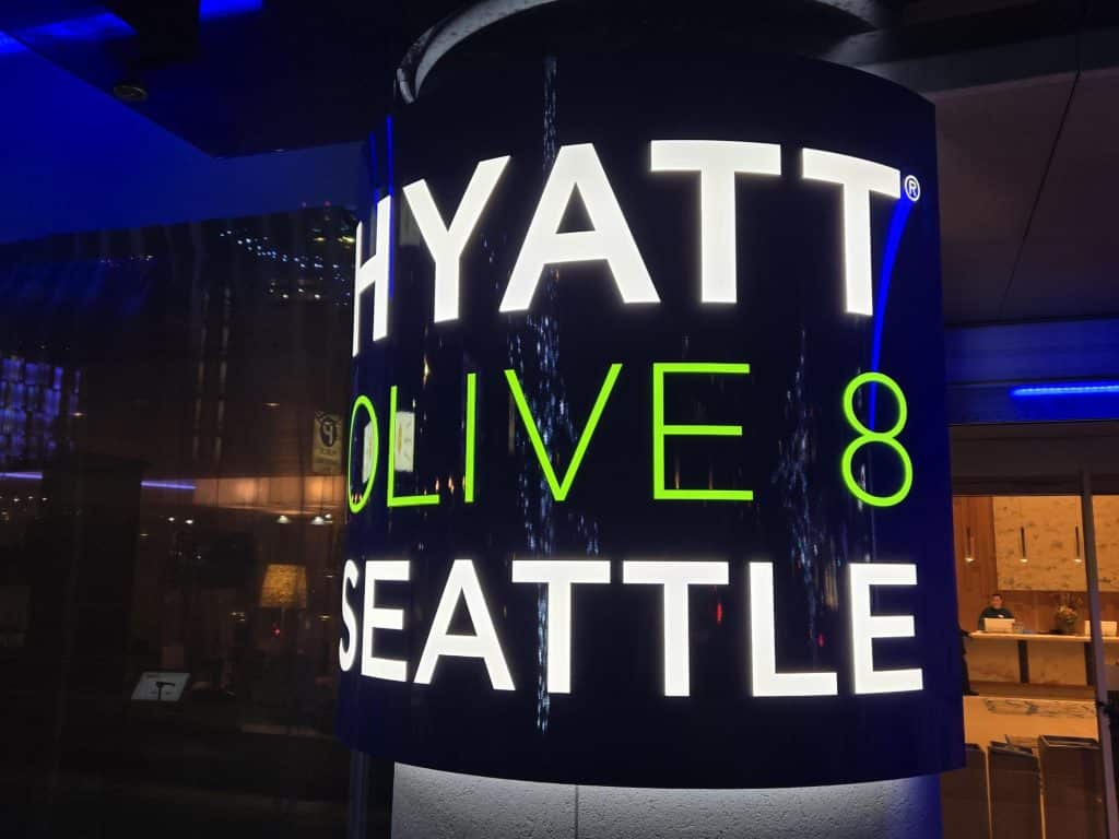 Illuminated sign for Hyatt at Olive 8 in Seattle, displayed against a dark background.